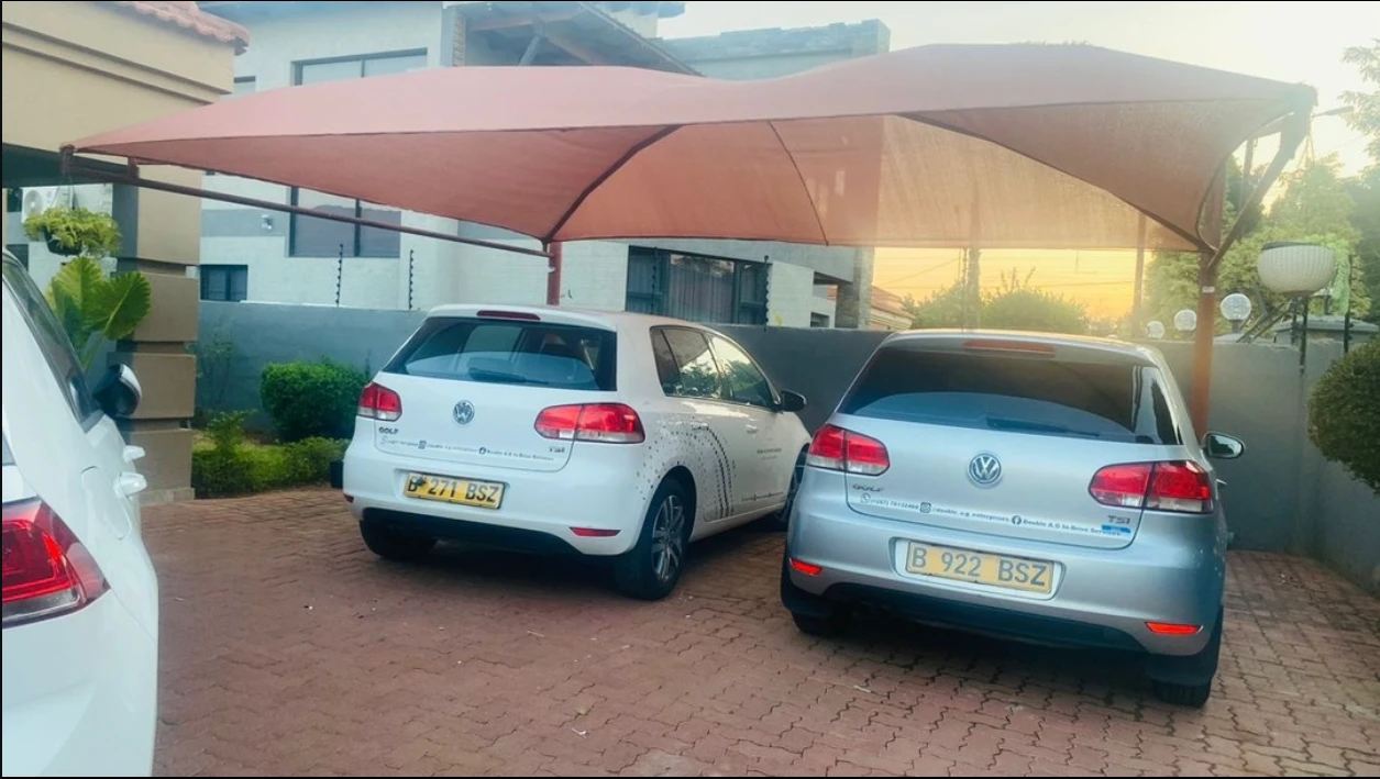 Two Volkswagen Golf hatchbacks parked under a carport