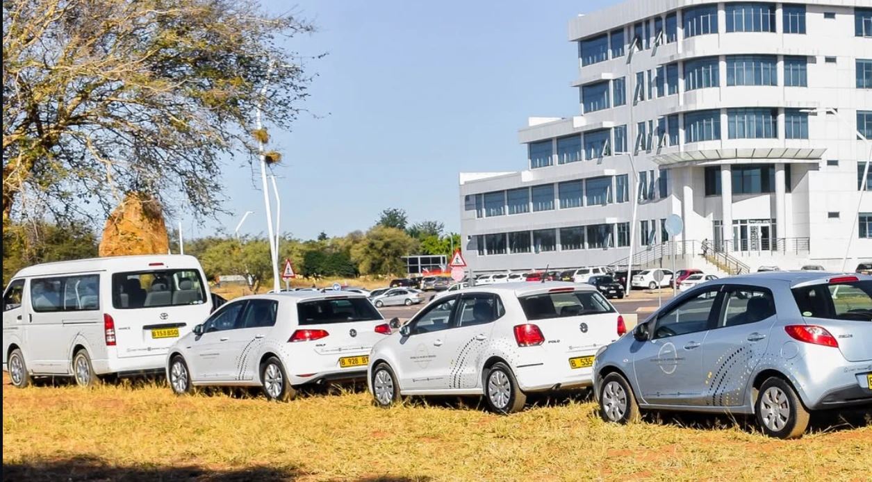 Double A. G van and hatchbacks parked outside an office building